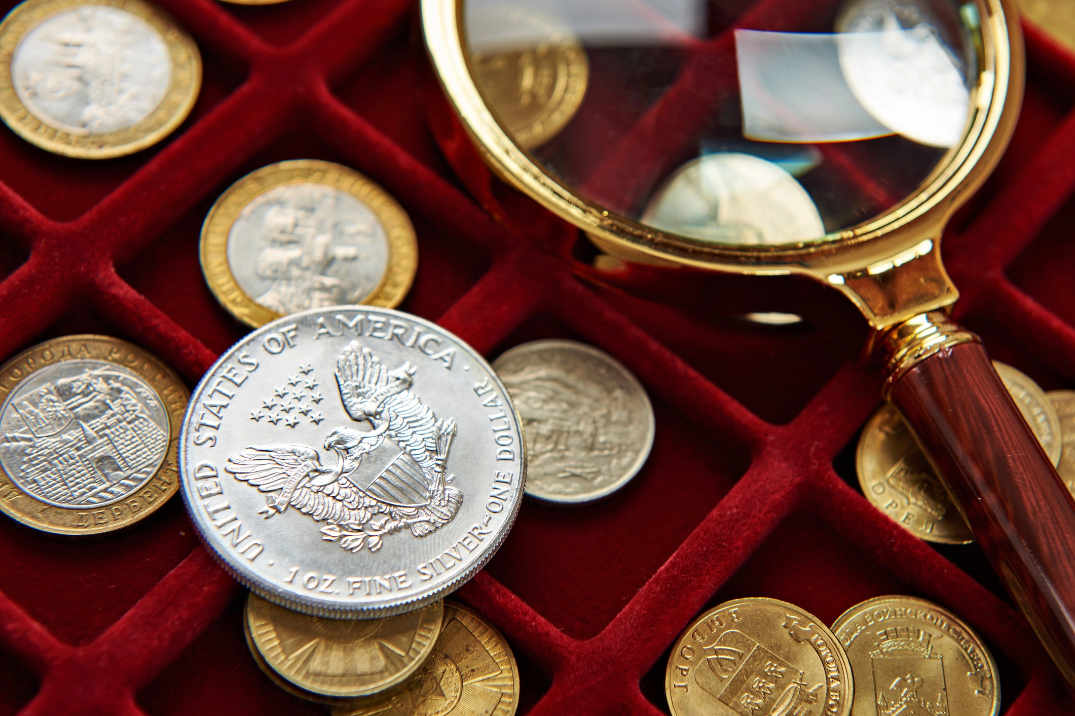 American silver dollar with magnifying glass on a velvet coin box